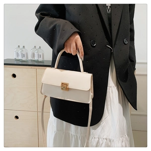 Moderne cremefarbene Henkeltasche mit goldenem Metallverschluss und schmalem Schulterriemen