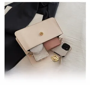 Dettaglio dell'interno della borsa beige che mostra la capienza per gli oggetti quotidiani