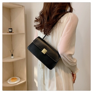 Dettaglio della borsa a tracolla vintage in pelle nera con fibbia dorata quadrata sottile