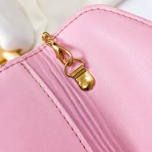 Close-up of durable gold metal hook and fine leather texture on the pink clutch bag
