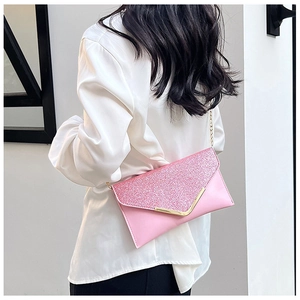 Detail of pink sequin envelope bag with V-shaped gold metal trim and chain strap