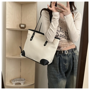 Mirror selfie showing the large beige canvas tote bag with black leather trim details