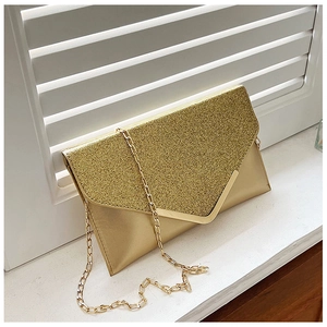 Detail of shimmering gold sequin evening clutch with V-shaped metal trim and chain