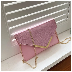 Detail of pink sequin clutch evening bag with golden V-shaped metal trim and chain