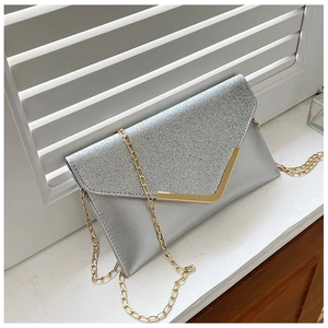 Detail of silver sequined evening clutch bag with gold V-shaped metal trim and chain strap