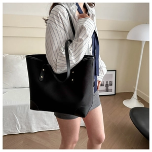 Detalle del bolso tote negro con esquinas reforzadas y asas con remaches resistentes