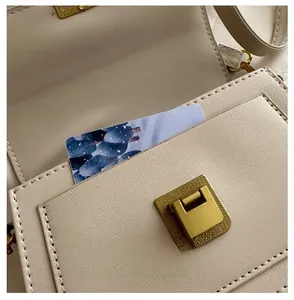 Detail of cream leather bag showing the interior storage pocket and gold buckle