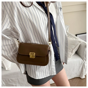 Close-up of brown vintage crossbody bag with matte PU leather and gold metal clasp