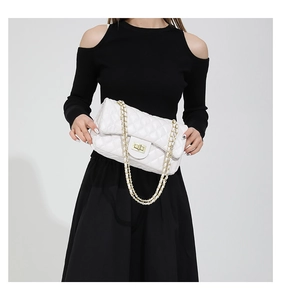 Close-up of white quilted leather crossbody bag with golden chain and metal turn-lock