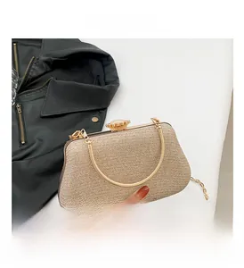 Close-up of golden glitter evening bag featuring vintage metal clasp and chain strap