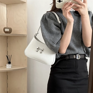 Borsa sottobraccio bianca in ecopelle con fiocco in metallo argento e tracolla