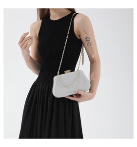 Close-up of sparkling silver sequin clutch bag with delicate gold chain strap for women