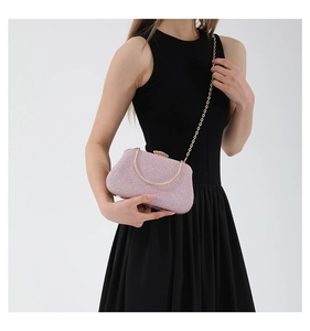 Detail of pink glitter evening clutch with gold metal handle and rhinestone clasp
