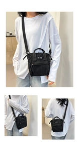 Detail view of black canvas crossbody bag with SPORT label and adjustable nylon strap