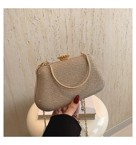 Close-up of golden evening bag with glitter texture and petal-shaped metal clasp