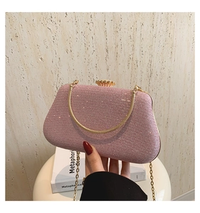 Detail of pink glitter evening bag featuring gold petal clasp and dual chain straps