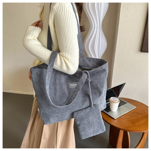 Detailed texture of grey corduroy tote bag with fashion label and matching coin purse