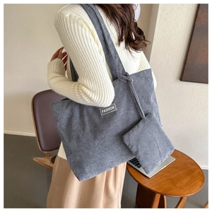 Detail of dark grey corduroy tote bag with FASHION label and matching small pouch