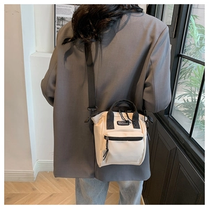 Vue de dos d'un mannequin portant un sac seau en toile crème avec sangles noires