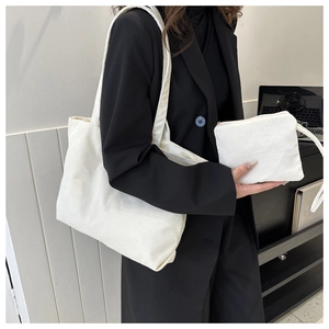Close-up of white corduroy tote bag and matching coin purse with vertical stripe texture
