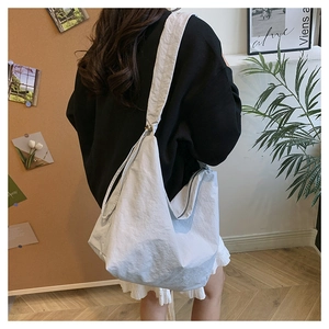 Minimalist large nylon hobo bag shown being worn by a model in a cozy home setting