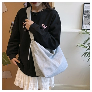 Detailed view of light blue nylon crossbody bag on a model with casual sweet outfit