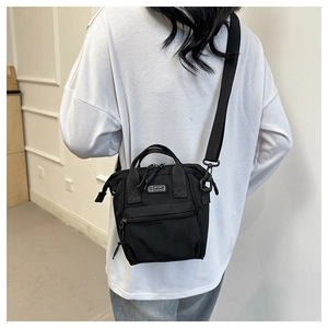 Détail de la vue arrière d'un petit sac bandoulière noir avec logo S SPORT sur un modèle