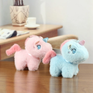 Close-up of pink and blue plush unicorn pendants with glitter horns and satin ribbons