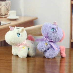 Close-up of plush unicorn charms in white and purple with shiny horns and star details
