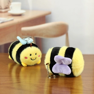 Close-up of cute plush bee keychains with soft yellow stripes and metallic rings