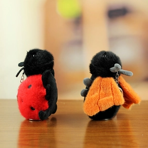 Close-up of plush insect pendants with soft red ladybug and fluffy orange bee details