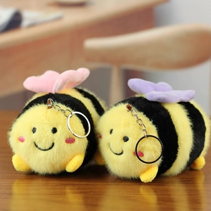 Detail shot of two plush bee charms with soft yellow stripes and pastel colored wings