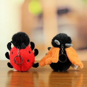 Detail of plush insect keychains featuring fluffy red ladybug and orange winged fly toys