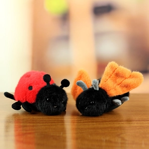 Close-up of plush insect pendants with soft ladybug design and metal hanging chains