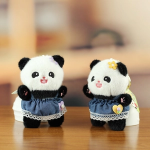 Detailed close-up of cute panda plush charms in denim dresses with delicate lace trim