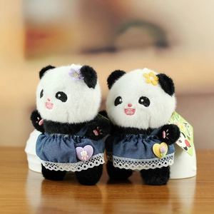 Pair of plush panda keychains wearing denim skirts with lace and colorful floral headbands