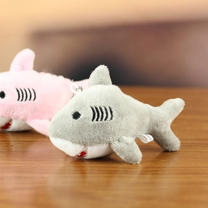 Close-up of plush shark keychains in pink and grey with detailed embroidery and metal chains