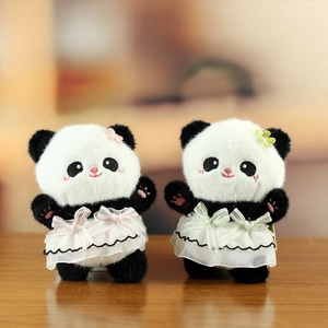 Detail of plush panda keychains wearing lace dresses with pink and green bows