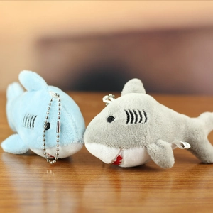Detail of plush shark keychains in blue and gray colors with silver metal bead chains