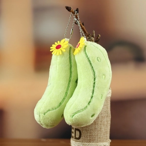 Detail von Gurken Plüsch Anhängern mit kleinen gelben Gänseblümchen an einem Zweig