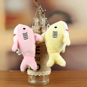 Detail of pink and yellow plush shark keychains with CE label on a decorative bottle