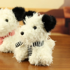 Close-up of Westie plush toy puppy with white long fur and striped knitted scarves