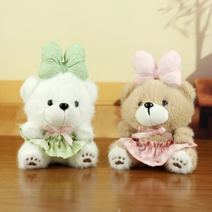 Detailed view of plush bears with oversized bows and checkered skirts on wood surface