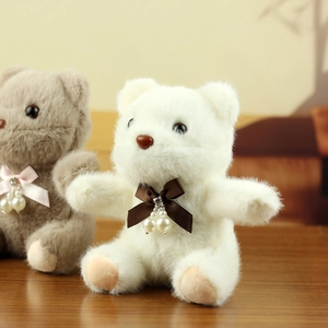 Detailed view of plush teddy bear charms with satin bows and imitation pearl accents