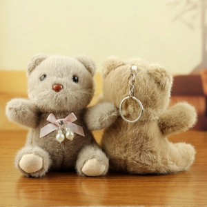 Front and back detail of plush teddy bear keychains with pink bows and pearl charms