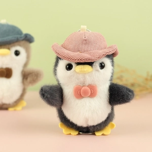Close-up of plush penguin charm featuring a pink corduroy cowboy hat and bow tie
