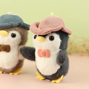 Close-up of cute penguin plush keychain with knitted hat and fluffy texture