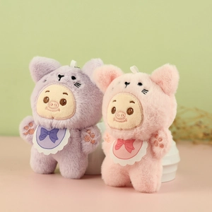 Détail de porte-clés cochons en peluche rose et violet avec bavoirs en dentelle douce