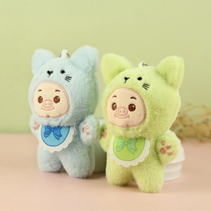 Gros plan de porte-clés cochons en peluche bleu et vert avec broderie fine