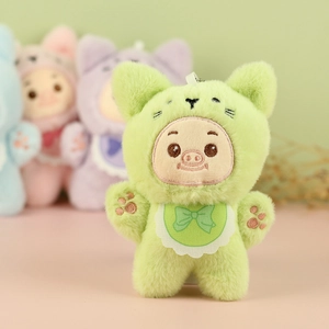 Détail du porte-clés cochon en peluche avec tenue verte à oreilles de chat brodée